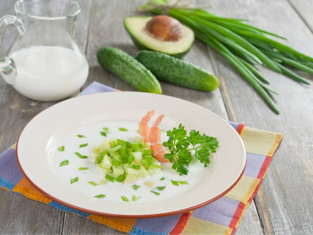 Talerz chłodnika z ogórka i awokado i produkty do niego. Obrazek w artykule 4 orzeźwiające pomysły na letnie śniadanie na upalne dni