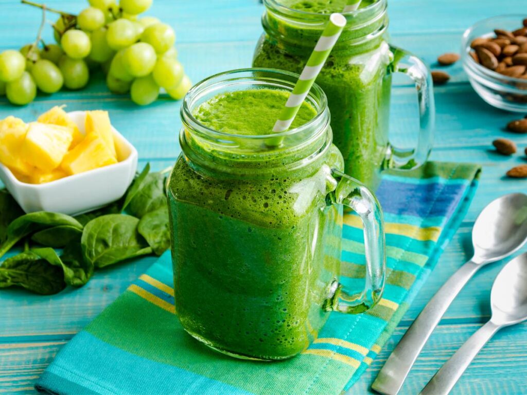 Smoothie zielone w kubeczkach ze słomkami. Obrazek w artykule 4 przepisy na śniadanie low carb, o niskiej zawartości węglowodanów