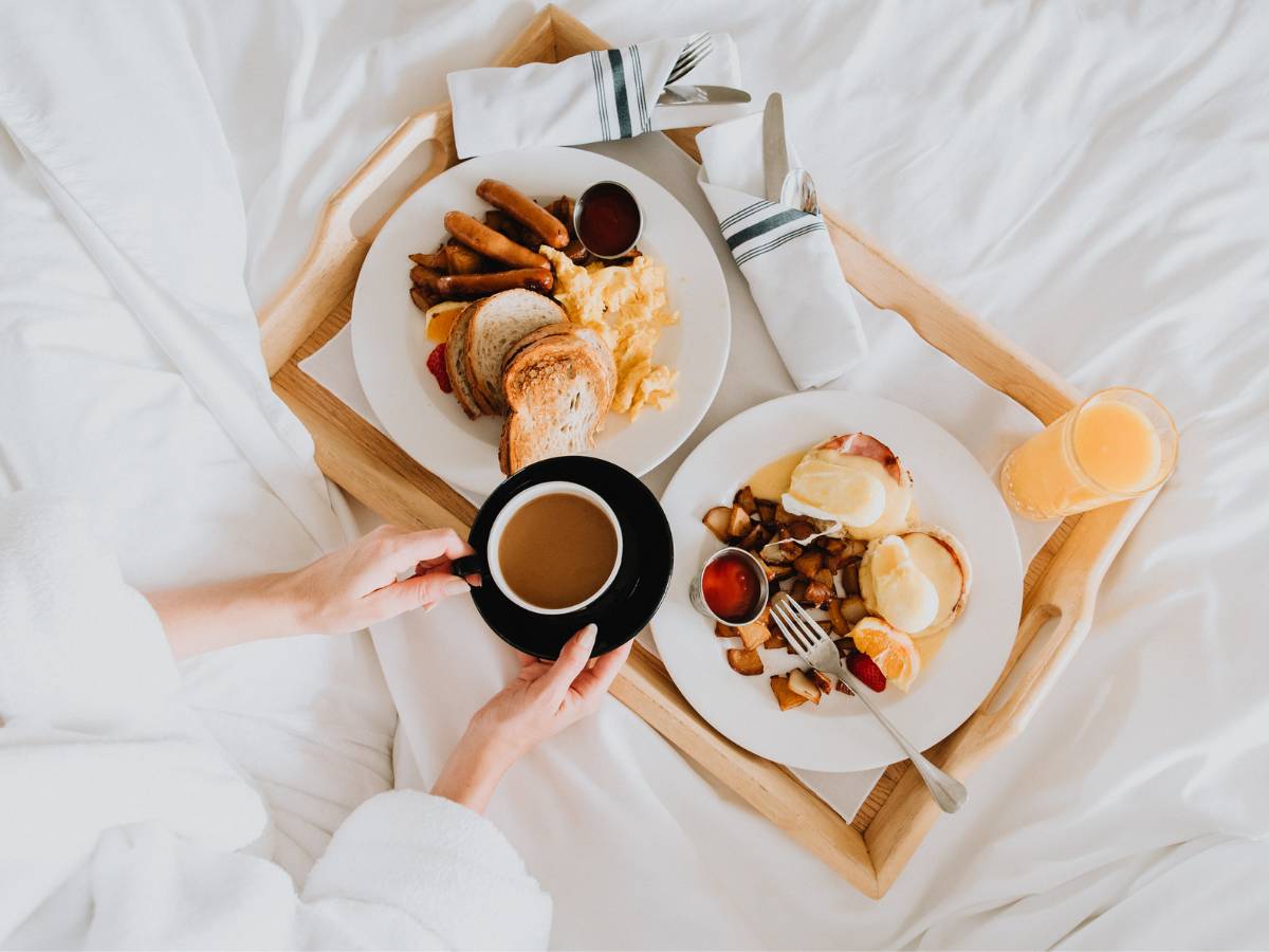 Dwa talerze z potrawami i filiżanka kawy. Obrazek w artykule 10 pomysłów na śniadanie do łóżka, idealnych na leniwy weekend