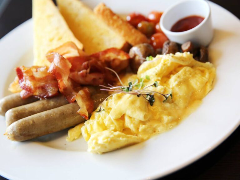 Talerz jajecznicy ze szczypiorkiem i boczkiem. Obrazek w artykule 5 tradycyjnych przepisów na polskie śniadanie, które warto znać