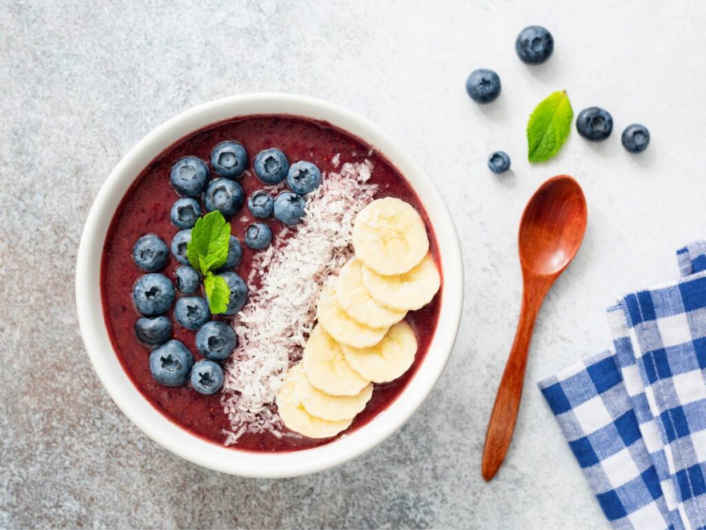 Miska smoothie bowl z jagodami i bananami. Obrazek w artykule 10 pomysłów na pożywne śniadanie dla głodomorów potrzebujących więcej kalorii