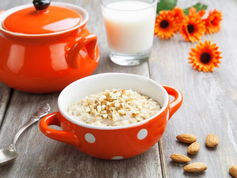 Czerwona miseczka z owsianką na mleku migdałowym. Obrazek w artykule 4 pomysły na śniadanie z niskim IG, które nie podnoszą cukru