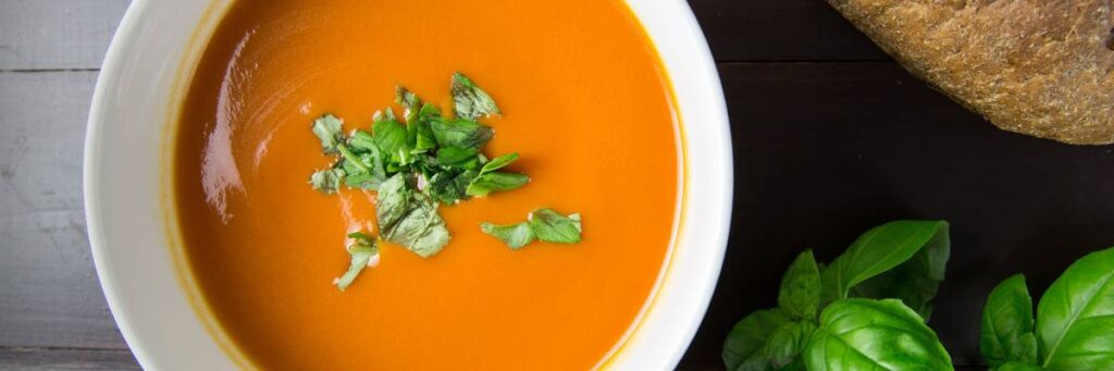 Talerz zupy pomidorowej z bazylią. Obrazek w artykule Zupa na śniadanie, która zawsze sprawdza się o poranku