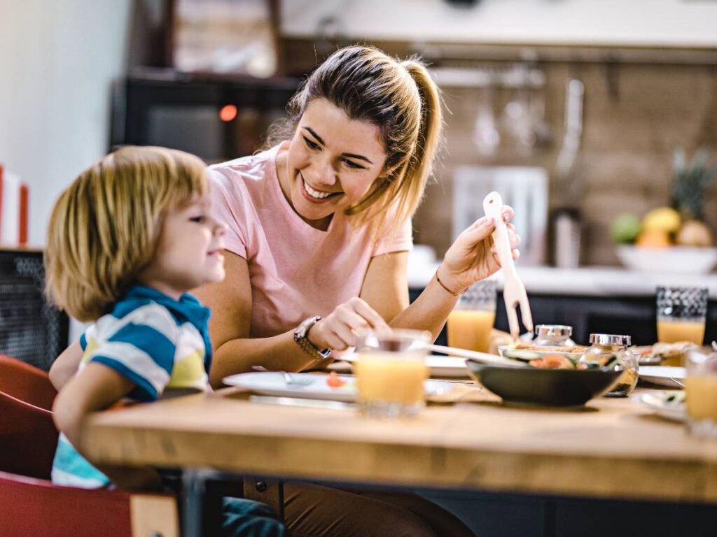 Kobieta z dzieckiem przy stole ze śniadaniem. Obrazek w artykule Spróbuj tego, jeśli nie wiesz co zjeść na śniadanie