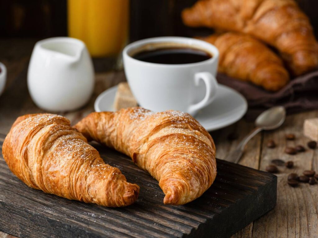 Filiżanka kawy i rogaliki. Obrazek w artykule Analizujemy, czy kawa na śniadanie jest dobrą opcją
