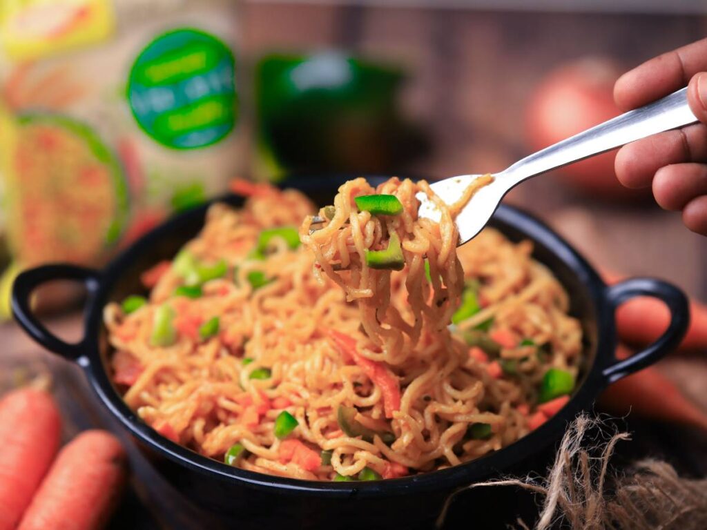 Makaron nitki ocieka na ciemnym sitku. Obrazek w artykule Ten makaron na śniadanie sprawi, że przestaniesz jeść kanapki