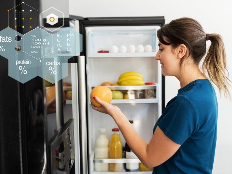 Kobieta przed otwartą lodwką. Obrazek w artykule 5 pomysłów na śniadanie 300 kcal, które zaspokoją Twój głód bez wyrzutów sumienia