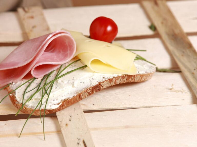 Kromka pieczywa z serkiem, szynka i pomidorek. Obrazek w artykule 5 pomysłów na śniadanie 400 kcal, od których nie będziesz chciał zacząć dnia inaczej