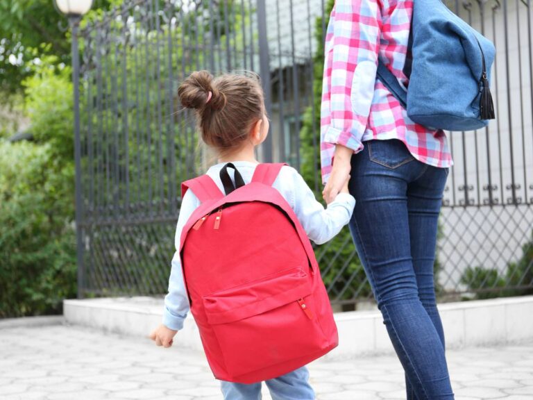 Mama i dziewczynka z dużym różowym plecakiem na chodniku. Obrazek w artykule 4 pomysły na śniadanie dla dziecka do szkoły, które wzbudzą zazdrość