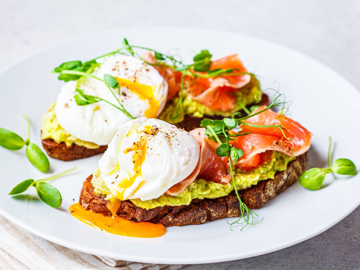 Grzanki z jajkiem w koszulce, pomidorem i pastą z awokado. Obrazek w artykule Odkryj śniadanie z awokado i jajkiem, które rozbudzi Twoje kubki smakowe