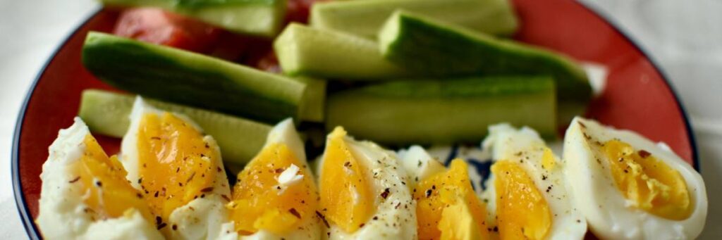 Jajka z sosem i szparagi na śniadanie. Obrazek w artykule 4 pomysły na śniadanie z dużą ilością białka, które wspomoże budowę Twoich mięśni