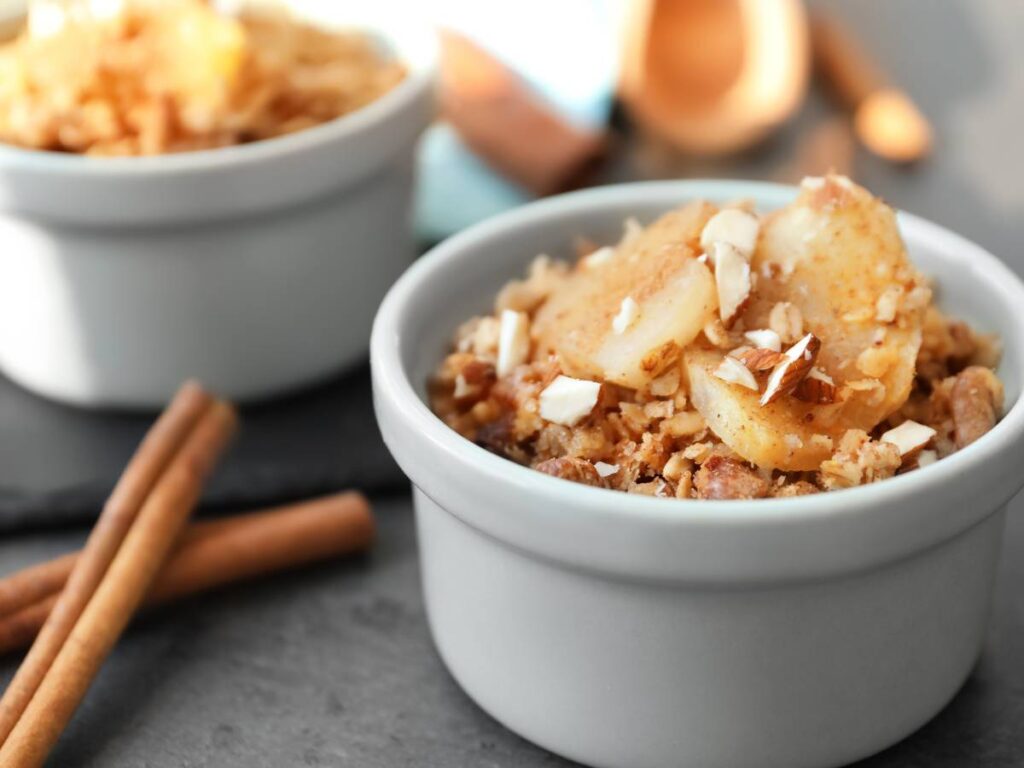 Miseczki z owsianki z jabłkiem i orzechami. Obrazek w artykule Analizujemy, czy śniadanie z jabłkiem jest dobrym pomysłem