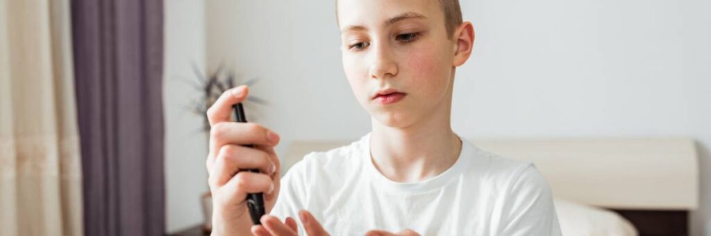 Chłopak bada sobie poziom cukru. Obrazek w artykule TOP 5 pomysłów na śniadanie dla insulinoopornych, które utrzymają Twój cukier w ryzach