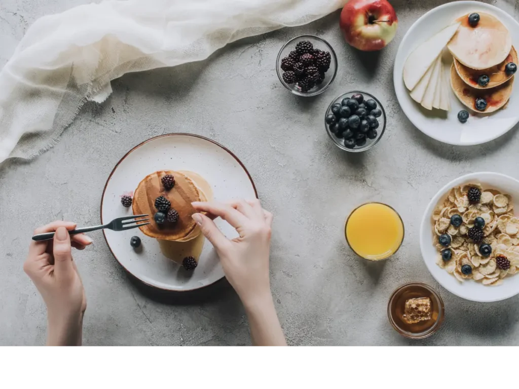 Stół z śniadaniem z owsianki, jogurtu i owoców. Obrazek w artykule 4 inspiracje na to, co zrobić na śniadanie, gdy brakuje Ci pomysłu