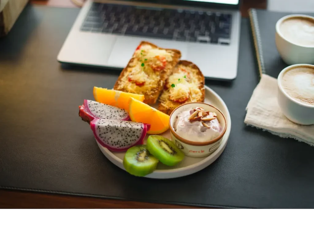 Talerz z tostami z serem, owocami i jogurtem. Obrazek w artykule 5 pomysłów na śniadanie do pracy, które dodadzą energii