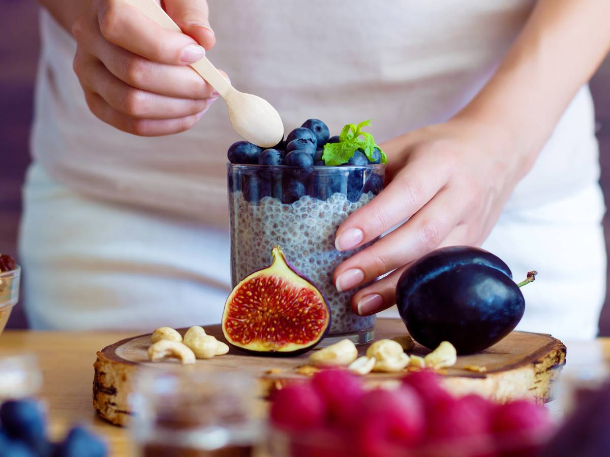 Kobieta przygotowuje pudding chia z owocami. Obrazek w artykule 4 inspiracje na fit śniadanie dla osób dbających o linię