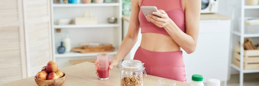 Kobieta i produkty fit na stole. Obrazek w artykule Idealne fit śniadanie na redukcji, które pomoże Ci schudnąć