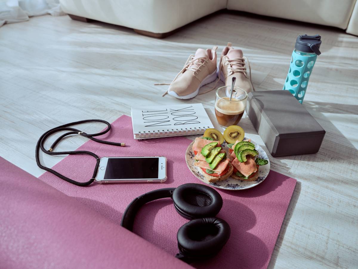 Talerz kanapek, kawa, smartfon, buty i inne akcesoria do treningu. Obrazek w artykule Doradzamy, jak powinno wyglądać śniadanie przed treningiem, abyś dostrzegał efekty treningowe